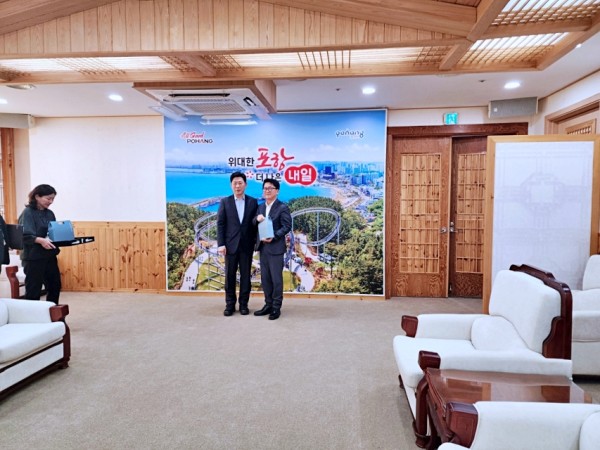 김원준 회장(오른쪽)이 박용선 포항시장으로부터 기념선물을 받은 후 기념촬영을 하고 있다.